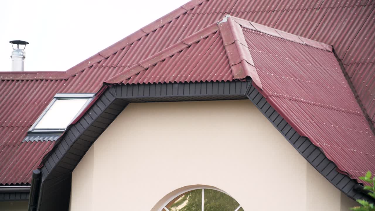 빨간색 파동 금속 지붕과 검은색 장식으로 된 집 외관