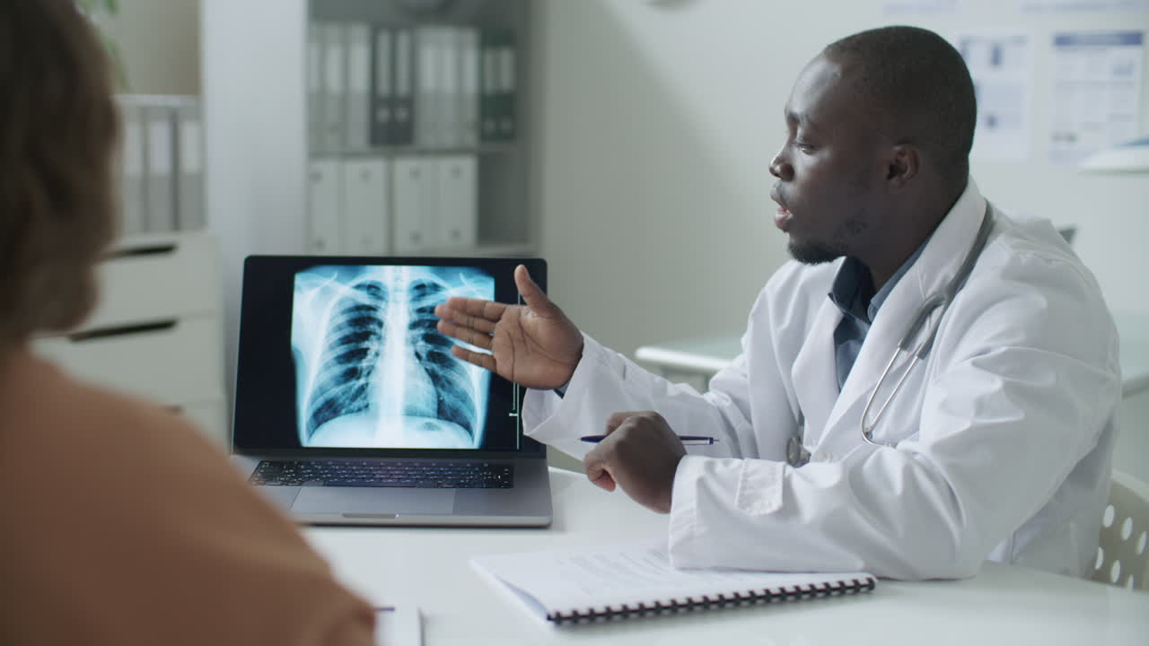 Black Doctor Discussing Chest X-Ray Image with Patient in Medical Office