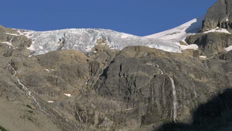 Agua-Del-Hielo-Derretido-En-El-Glaciar-Que-Fluye-Sobre-El-Acantilado-Rocoso-Del-Pico-De-La-Montaña-Joffre-En-Verano-En-Columbia-Británica,-Canadá