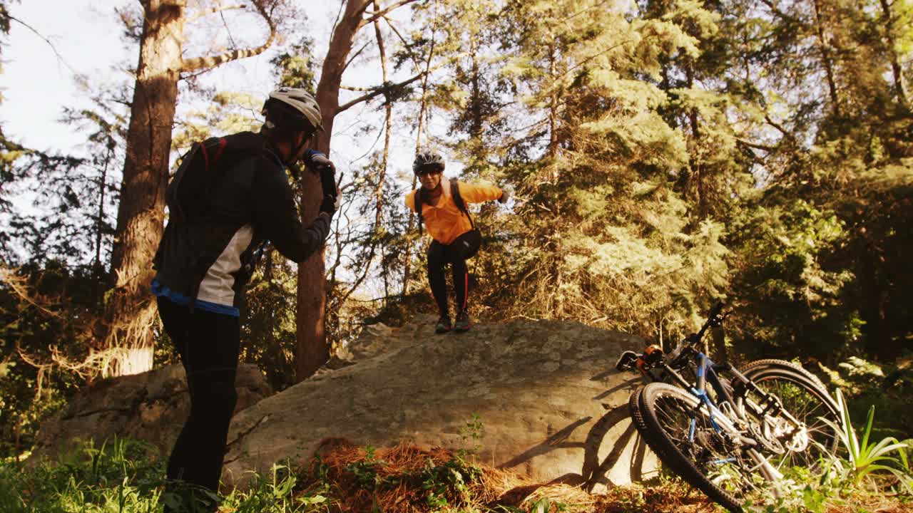 Man taking picture of a woman in the forest