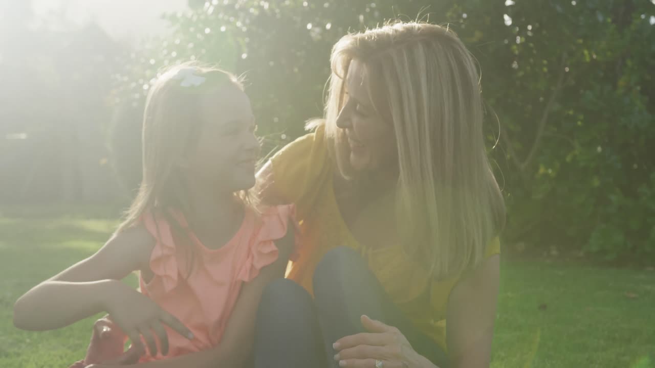 고위 백인 여성과 그녀의 손녀가 정원에서 시간을 보내고 있습니다.