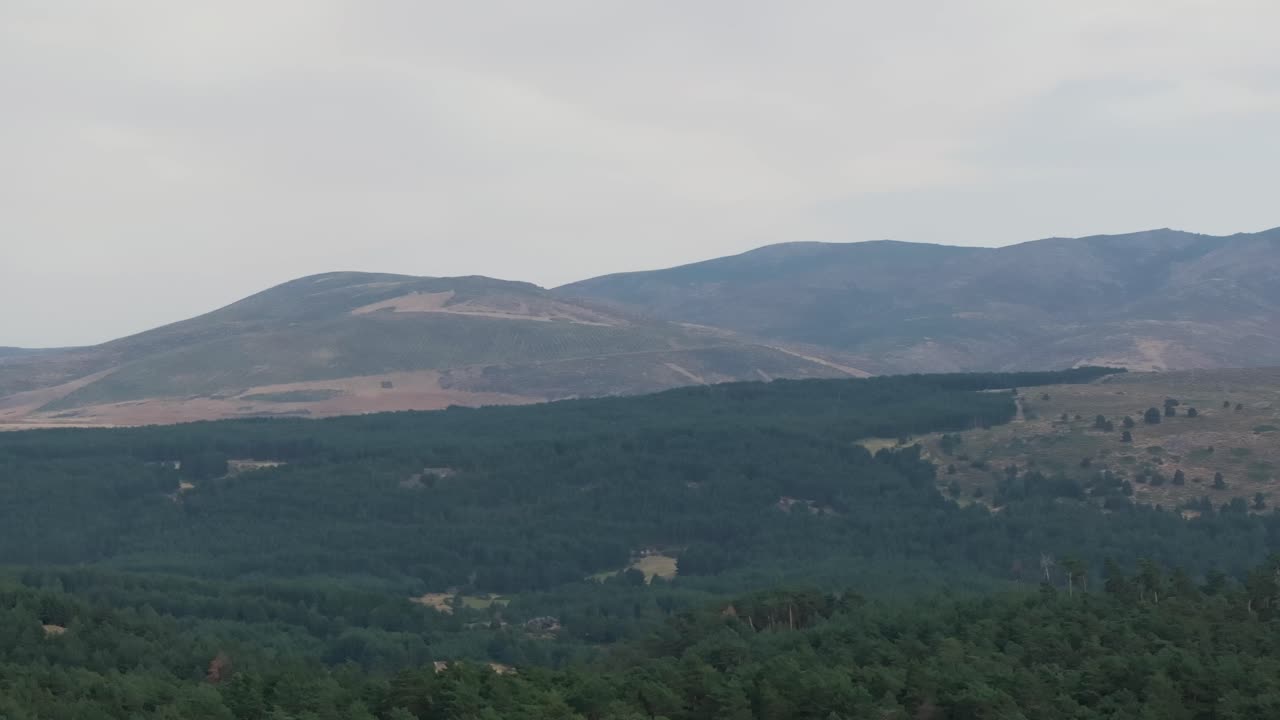Filmed in 70mm with a drone and by rotating the camera we appreciate the fascinating mountain system that Gredos has, and all its slopes are with lush wild pine forests, there is a whitish sky.