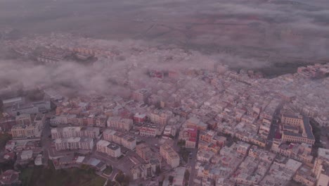 Ginosa-Italian-town-in-the-south-with-mist,-aerial