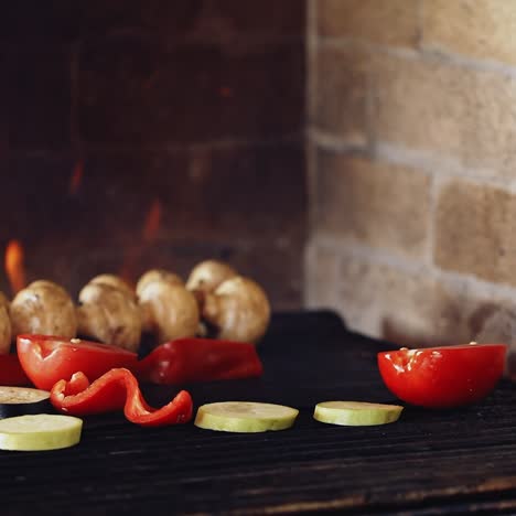 grilling organic food. hand of a professional cook putting fresh pieces of vegetables on a hot stove. tasty composition on fire. healthy food.
