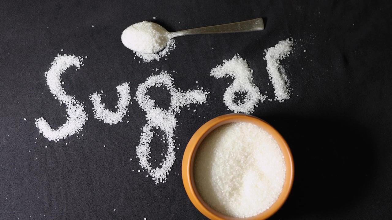 Sfondo di zucchero granulato con scritte artistiche di zucchero e spazio per il testo per un tema nutrizionale.