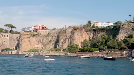 boats navigate near cliffs in sorrento, italy