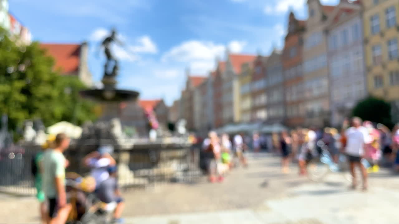 Blurry Scenery Of Gdansk Old Town With Tourists Taking Photos Of The Fountain Of Neptune In A Plaza - wide shot