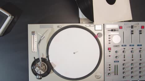 the musician removes the record from the turntable