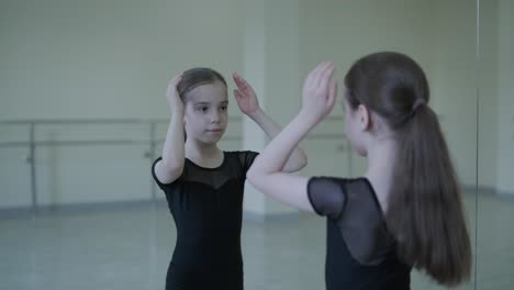 young ballerina practicing dance moves in studio