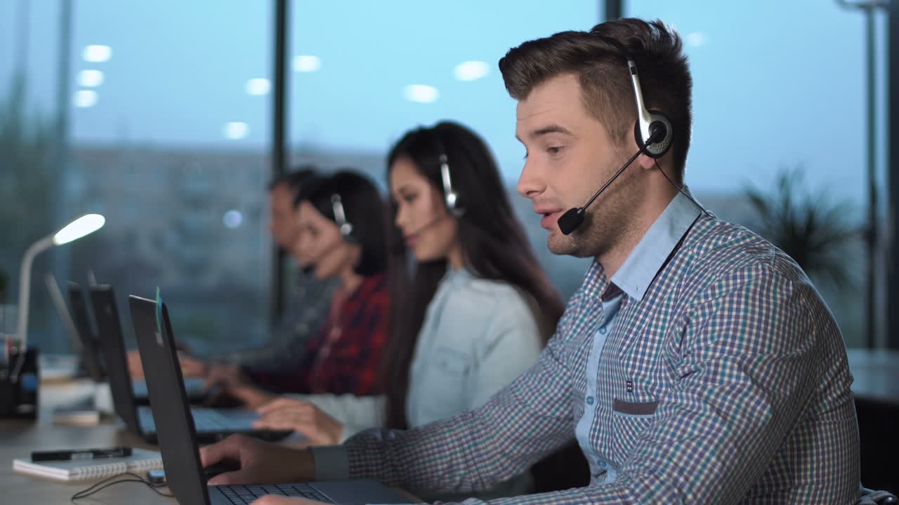 Call center team working with headsets and laptops