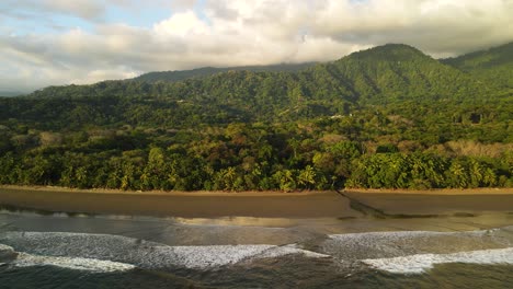 Amplio-Pan-De-Tiro-De-Drones,-De-Hermosas-Playas-Y-Verdes-Paisajes-De-Montaña-Con-Olas