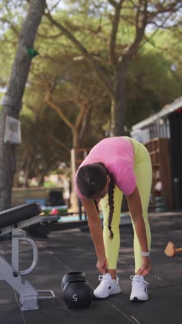 woman exercising with a kettlebell at an outdoor gym