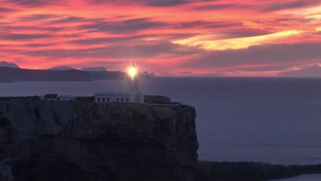 sunset aerial shining lighthouse cavalleria, menorca spanish cliff ocean coastline panoramic gradient golden hour skyline