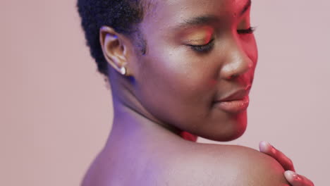 mujer afroamericana con cabello oscuro corto en luz azul y rosa, cámara lenta