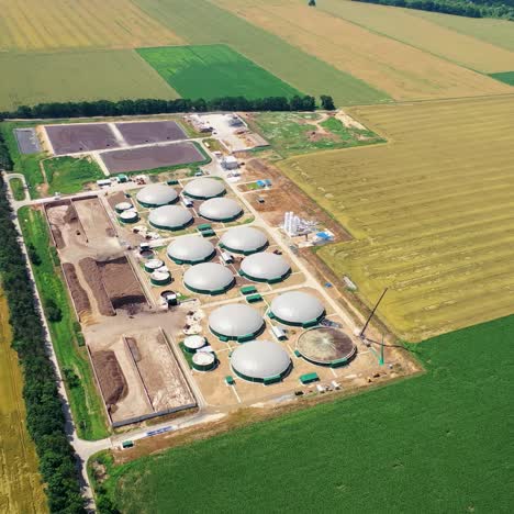 aerial footage of biogas plant. aerial view over biogas plant and farm in green fields
