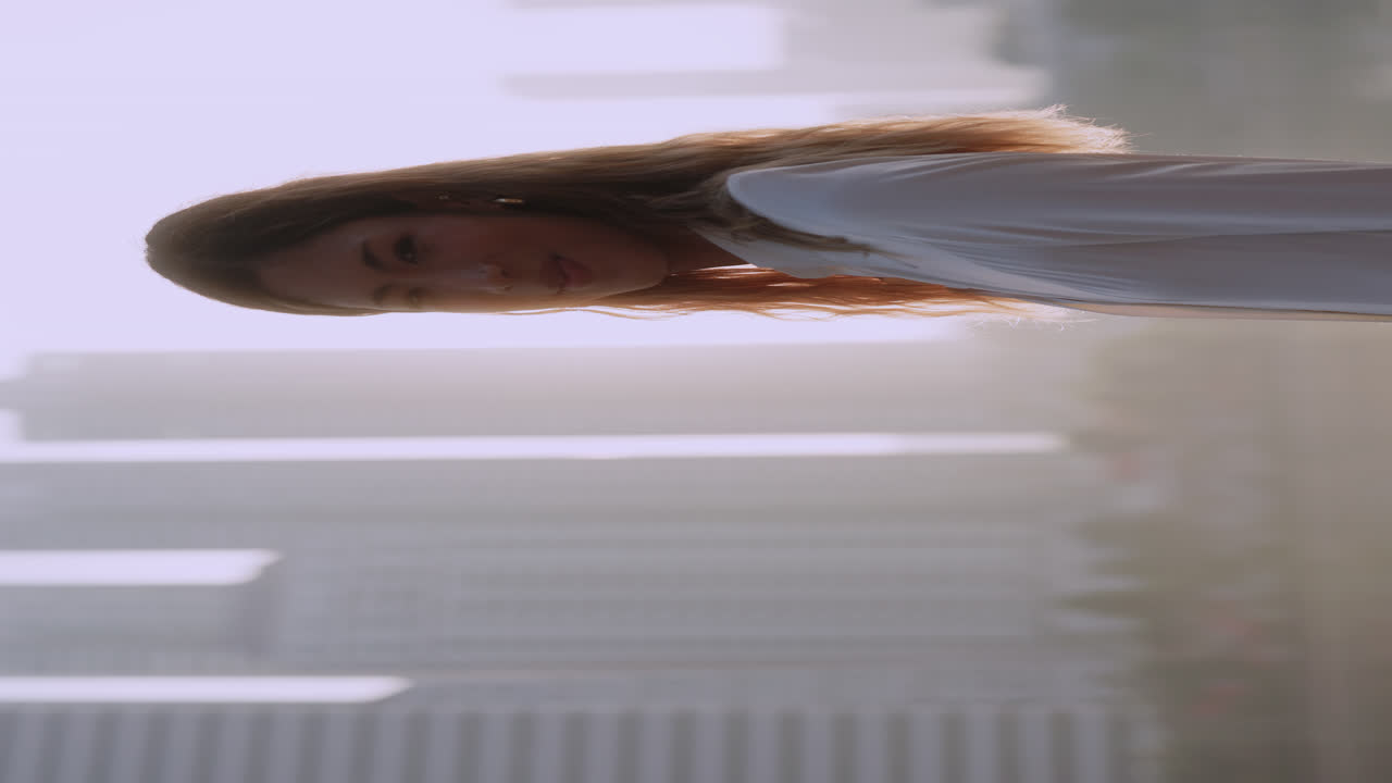 A smiling woman with long hair against a city background