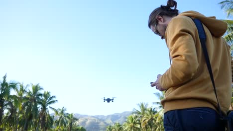 un piloto de drones caucásico se para y lanza un drone en un largo camino que conduce a un rancho de hawaii en la costa norte de oahu