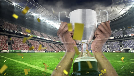 animation of confetti falling over caucasian man holding silver cup in sports stadium