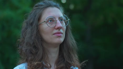 a young woman meditating with eyes open and many mosquitoes around, close up