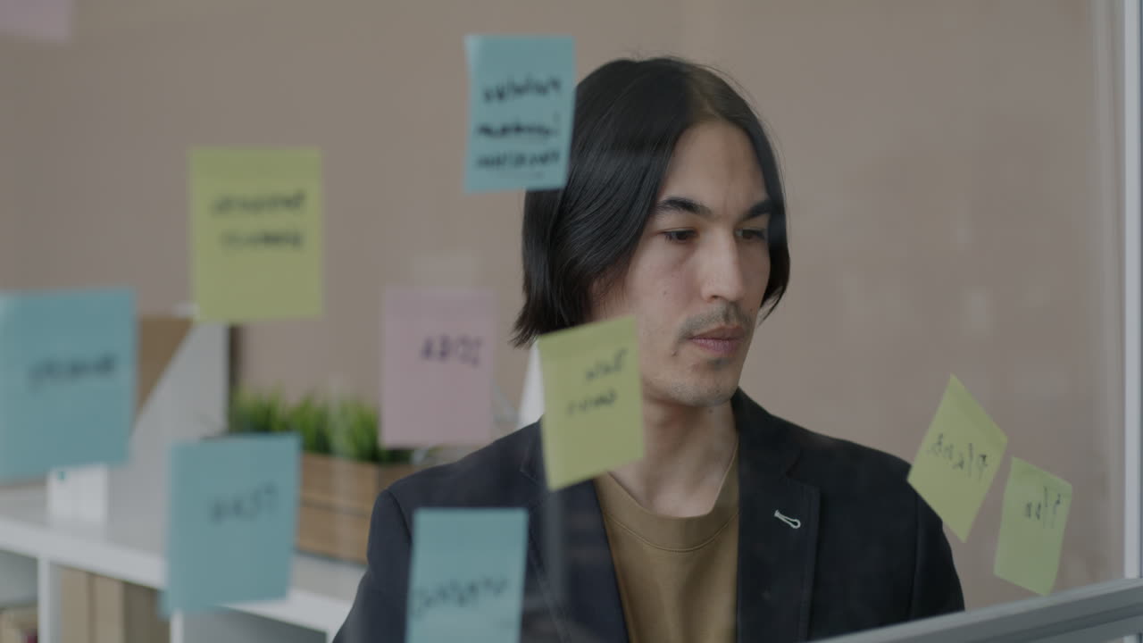 Man Brainstorming with Sticky Notes
