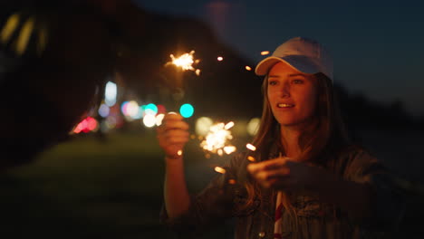 Junge-Frau,-Die-Mit-Wunderkerzen-Spielt,-Feiert-Silvester-Mit-Einer-Freundin-Und-Hat-Einen-Lustigen-Abend-Mit-Wunderkerzen-Feuerwerk-Und-Gemeinsamer-Feier-In-Der-Nacht