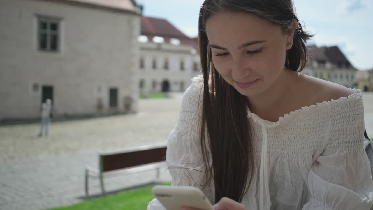 밖에서 스마트폰을 사용하는 젊은 여성