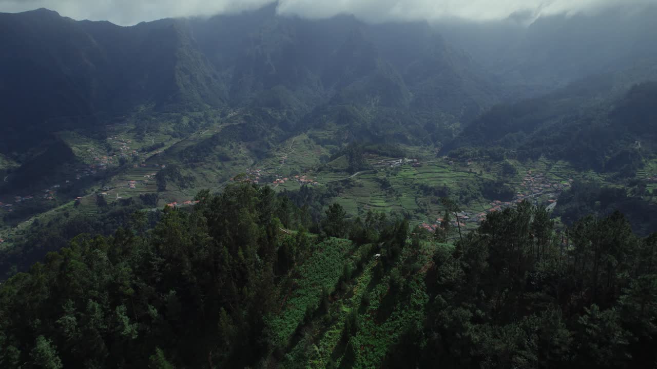 Aerial View of a Mountainous Valley with Terraced Fields and Village