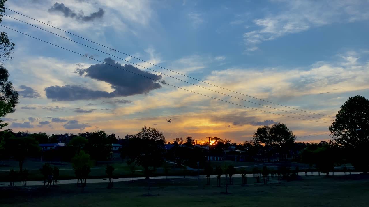 4K UHD Sunset Silhouette of Careflight Rescue Helicopter flying over downtown Stanthorpe district, Queensland Australia, Low Angle View. Emergency Medivac, Granite Belt Country life.