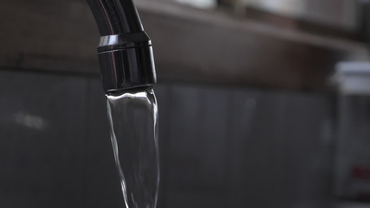Kitchen sink spout turning on with flowing water