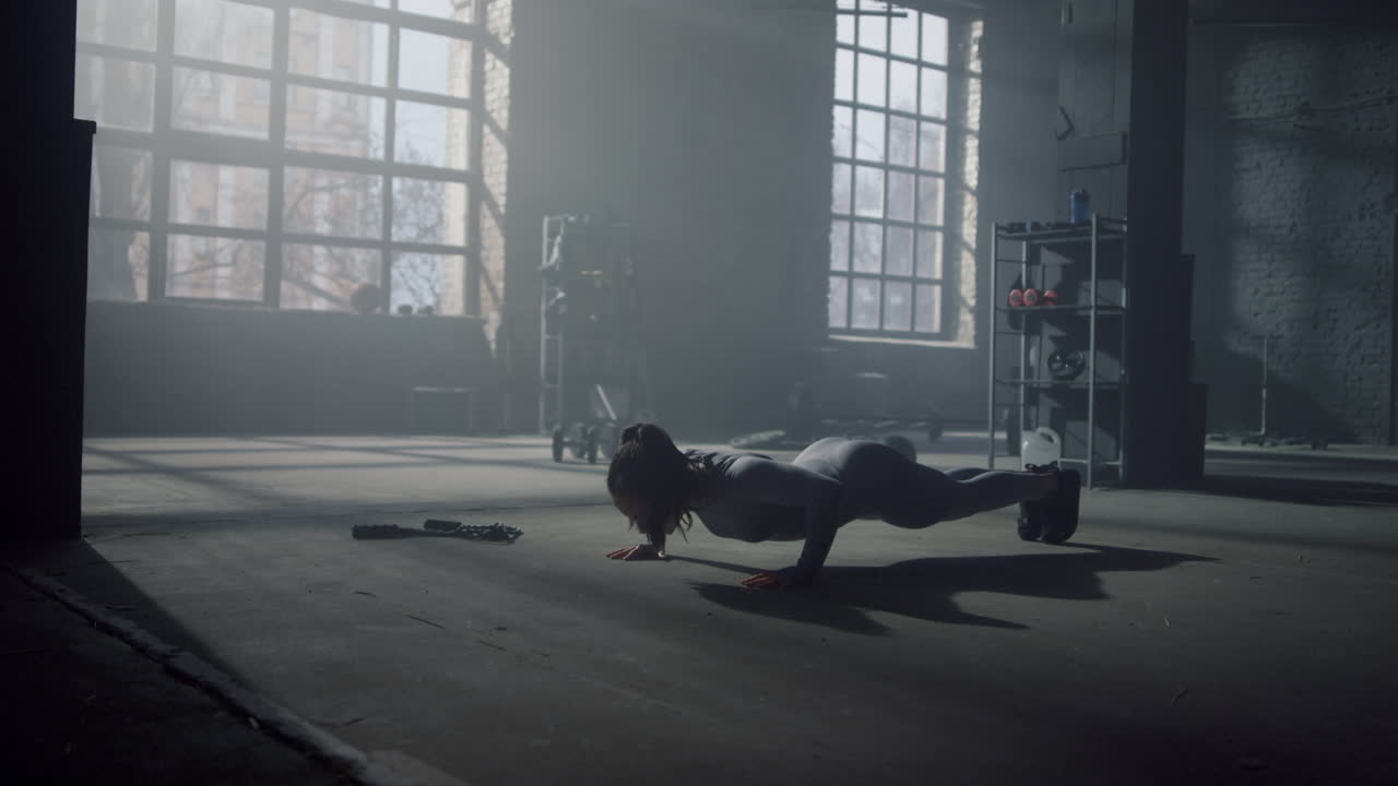 체육관에서 바닥에서 푸시업을 하는 여자. 피트니스 소녀 복근 훈련