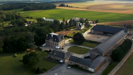 Vista-Aérea-De-Un-Castillo-En-Bordeaux-En-El-Sur-De-Francia,-Vemos-Los-Campos-Detrás