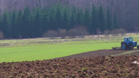 exhaust gas from old soviet tractor while farmer cultivate farmland field