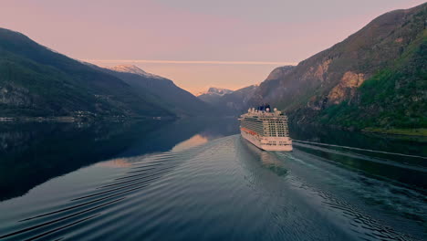 aerial view of gigantic cruiser ship on tranquil fjord between mountains of norway in the morning - wide shot