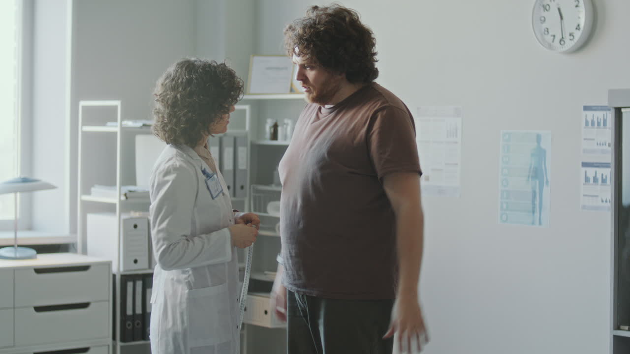 Doctor measuring patient's waist circumference
