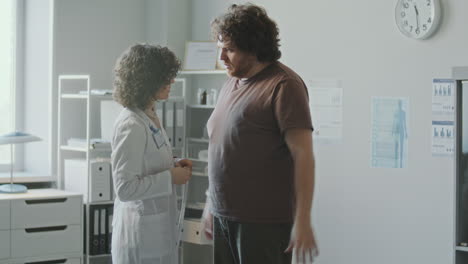 doctor measuring patient's waist circumference