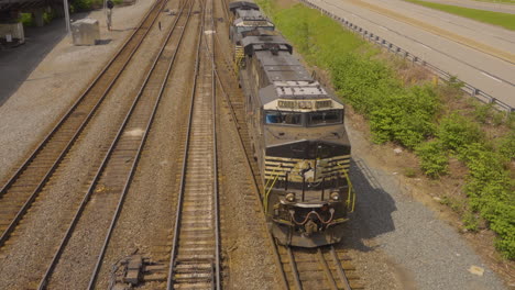 vista superior de un motor de tren retrocediendo por las vías del ferrocarril para desaparecer del marco
