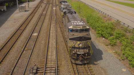 top view of a train engine backing down the railroad tracks to disappear from the frame