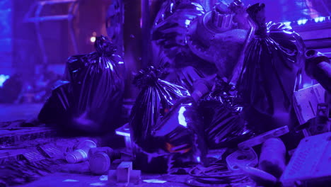 trash bags and debris in urban environment illuminated by purple light