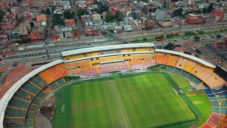 aerial orbit establishing the el campin stadium, with completely empty stands on a sunny day in bogota, colombia.