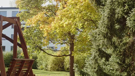 Yellow-Tree-and-bench-in-Autumn-in-Park,-Jyvaskyla,-Finland---60fps,-4k