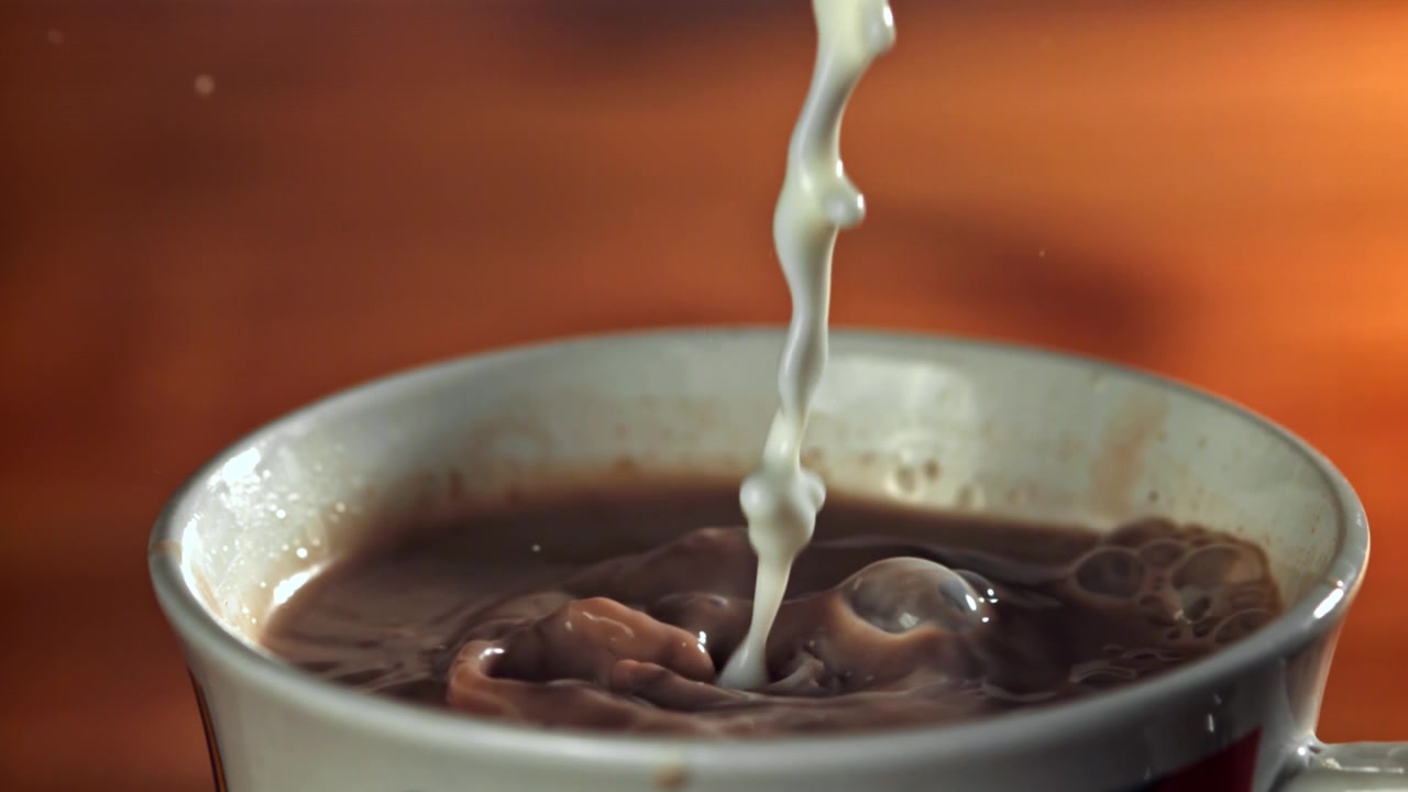 Latte versato al rallentatore in una tazza di cioccolata calda