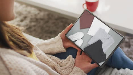 mujer caucásica usando una tableta en casa para comprar en línea, cámara lenta