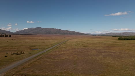 aerial view of empty desert highway leading through dry plains in sunshine