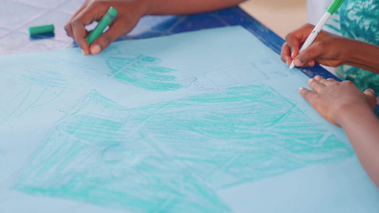 Black mother and child collaborating on large paper, two sets of dark hands filling blue sheet with sweeping green strokes, joyful classroom vibe, community creativity and mentorship