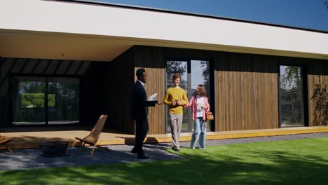 real estate agent showing modern house to couple