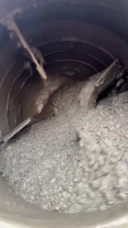 close up of portable concrete mixer drum mixing a fresh pour on a construction site.