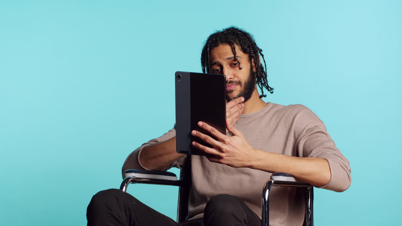 Person with disability doing digital art on drawing tablet, studio background