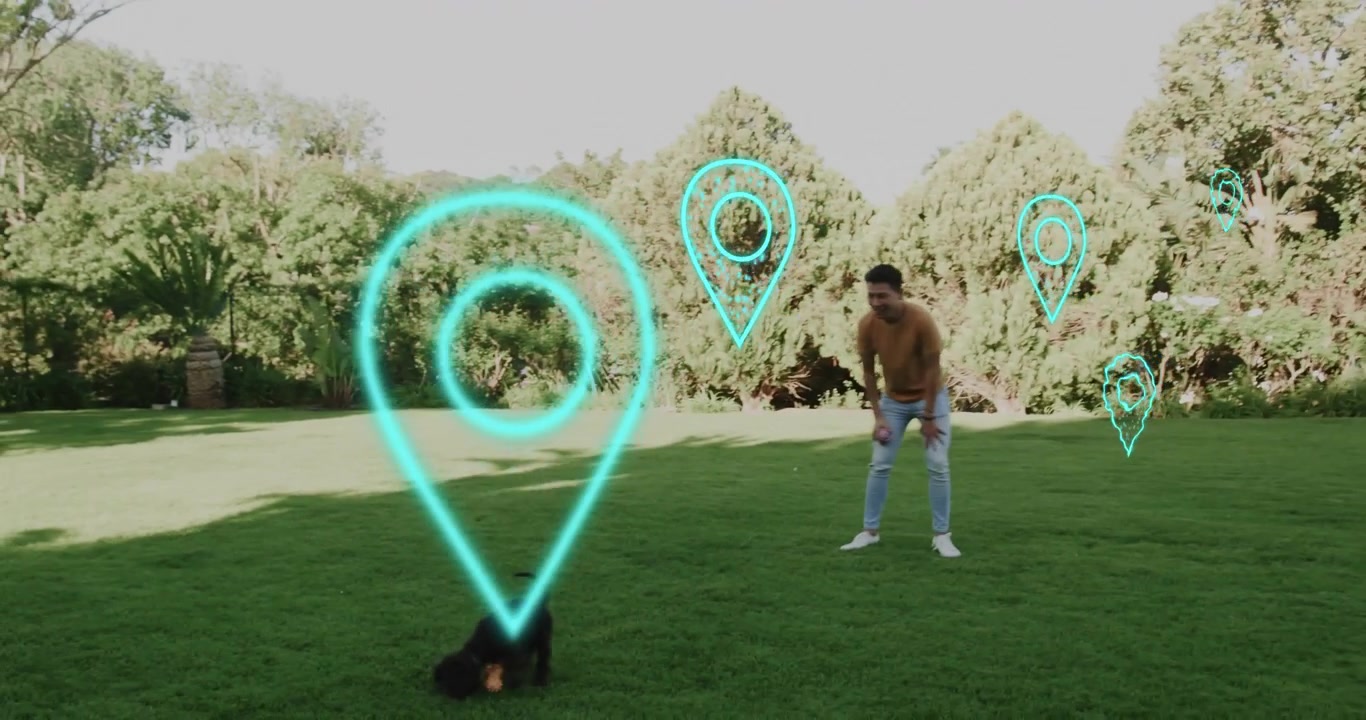 Cucciolo che si avvicina a un uomo che tiene un giocattolo arancione in giardino, attivando indicatori luminosi turchesi per la cura degli animali domestici.