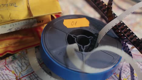 Close-up Vintage 8mm film reel unraveled on old travel map SLIDE SHOT
