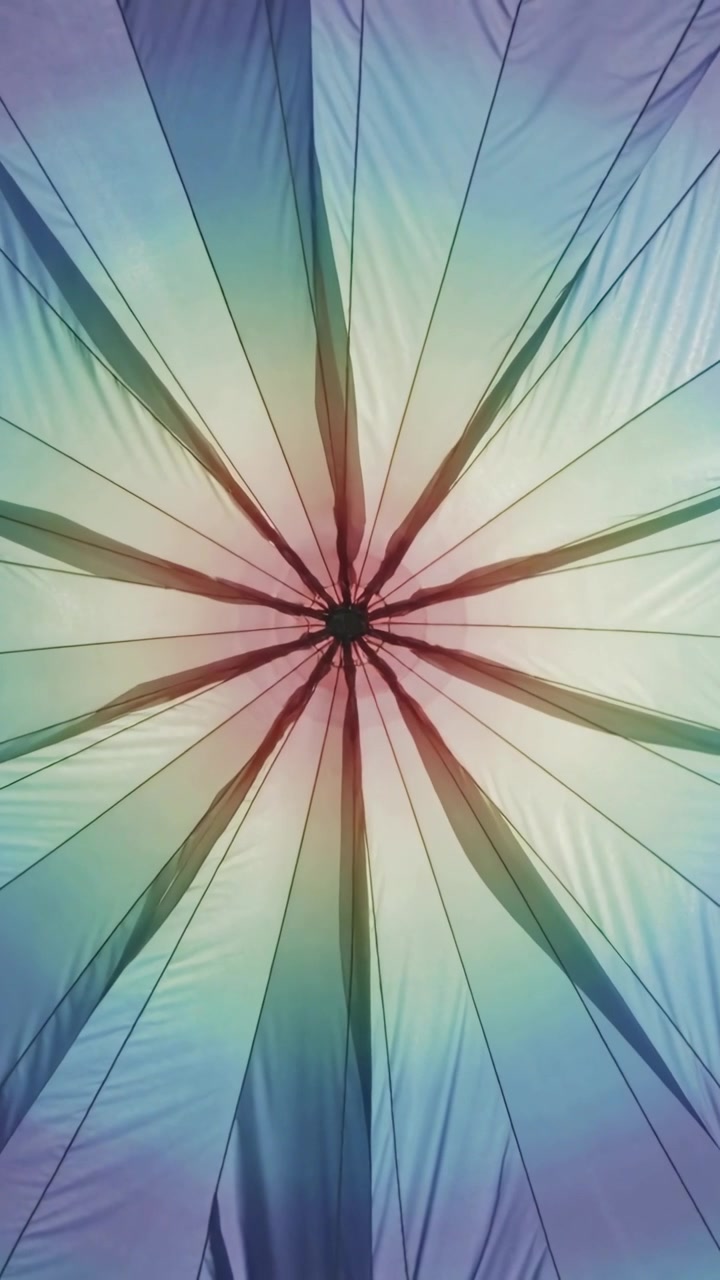 Video verticale: Tettoia in tessuto radiale che ondeggia dopo che una luce soffusa si sposta sulle cuciture del mozzo centrale.